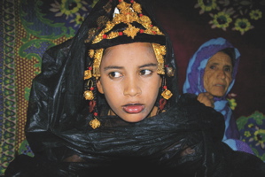 Bride after unveiling, in background the woman who took off her veil